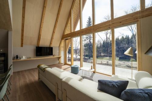 a living room with a couch and a large window at ERUSA Rusutsu in Rusutsu