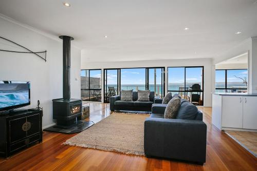 a living room with two couches and a fireplace at IL Mare - "Expansive Ocean Views" in Apollo Bay