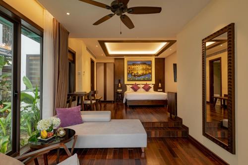 a living room with a couch and a bed at The Saga Hotel Hoi An in Hoi An