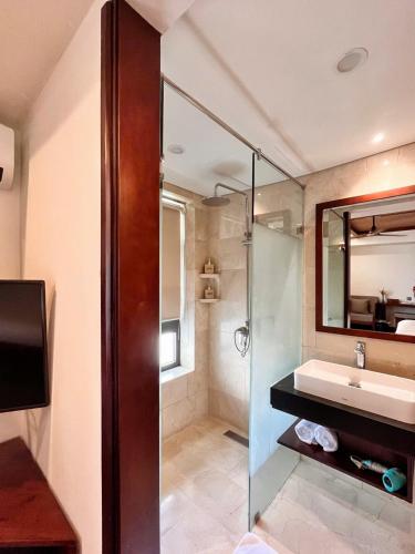 a bathroom with a sink and a shower with a mirror at Hoi An Eco Lodge & Spa in Hoi An