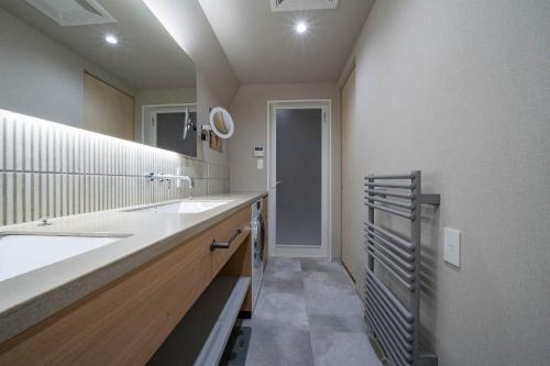 a bathroom with a sink and a mirror at ERUSA Rusutsu in Rusutsu