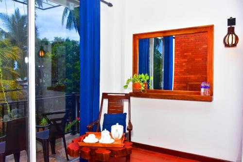 a room with a window and a table with a mirror at Yala Grand Homestay in Tissamaharama