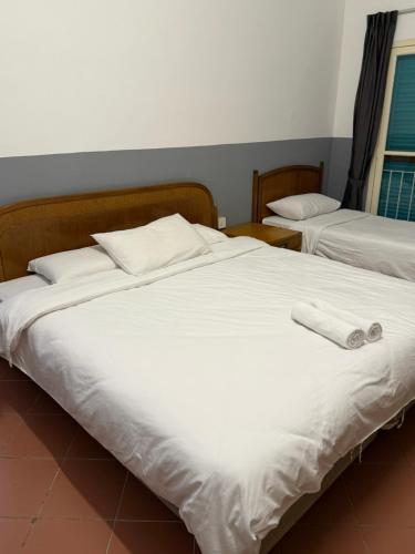 a bedroom with two beds with white sheets at Heeren Inn at Jonker Walk in Melaka