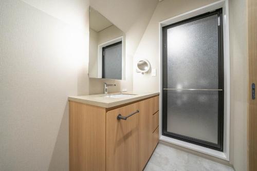 a bathroom with a sink and a mirror at ERUSA Rusutsu in Rusutsu