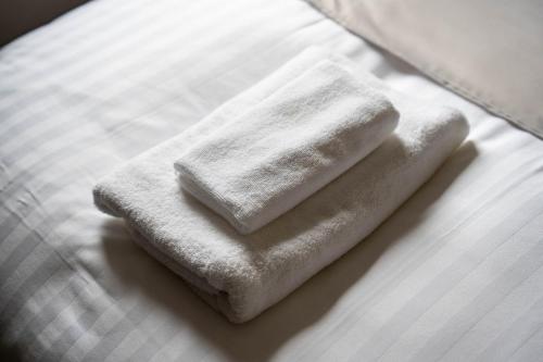 two towels sitting on top of a bed at ERUSA Rusutsu in Rusutsu