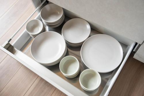 a bunch of white bowls in a drawer at ERUSA Rusutsu in Rusutsu