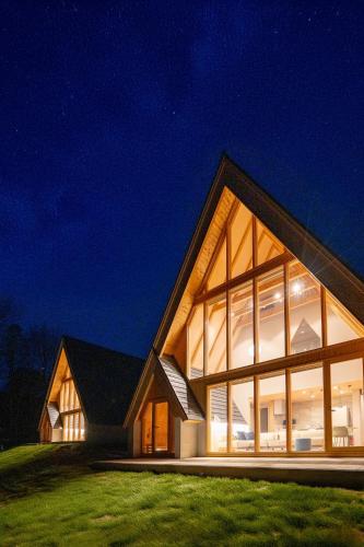 a house with large glass windows at night at ERUSA Rusutsu in Rusutsu