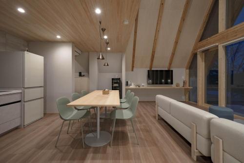 a kitchen and dining room with a table and chairs at ERUSA Rusutsu in Rusutsu