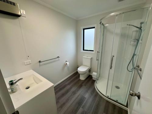 a bathroom with a shower and a sink and a toilet at 15b Caverhill Close in Hanmer Springs