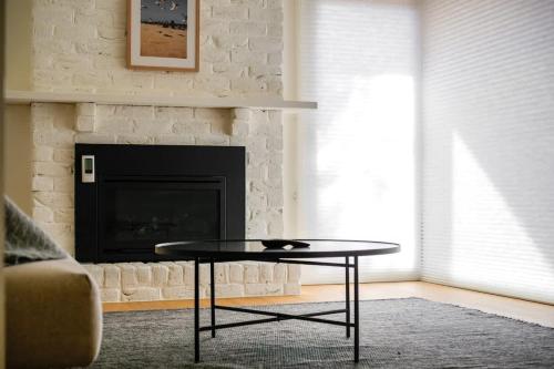 sala de estar con mesa de centro frente a una chimenea en Relaxed Family Coastal Retreat in Leafy Mt Martha, en Mount Martha
