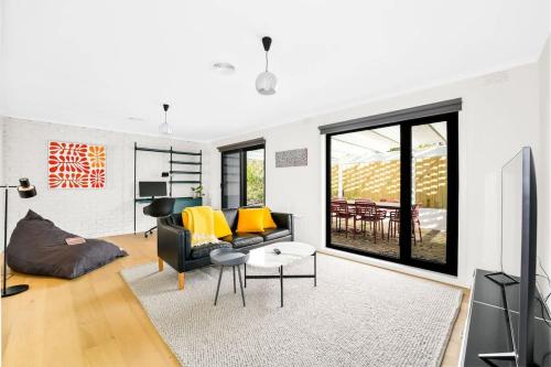 a living room with a black couch and yellow pillows at Relaxed Family Coastal Retreat in Leafy Mt Martha in Mount Martha