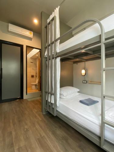 a bedroom with two bunk beds and a bathroom at Monomer Hostel Bangkok in Bangkok