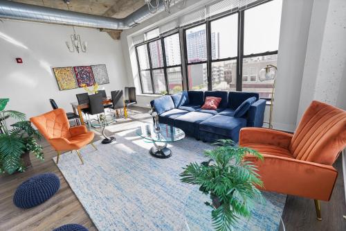 a living room with a blue couch and orange chairs at McCormick Place Luxurious and Spacious 3BR in Downtown Chicago with Optional Parking Sleeps 10 guests in Chicago
