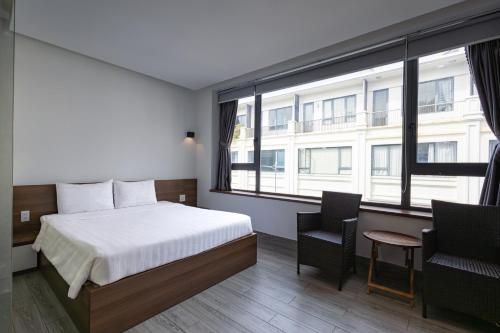 a hotel room with a bed and a large window at HAKU Boutique Hotel Tuy Hoà - APEC Mandala in Tuy Hoa