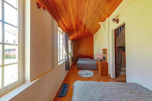 Mộc Thiện Tâm Homestay في دالات: غرفة نوم بها سريرين ونافذة كبيرة