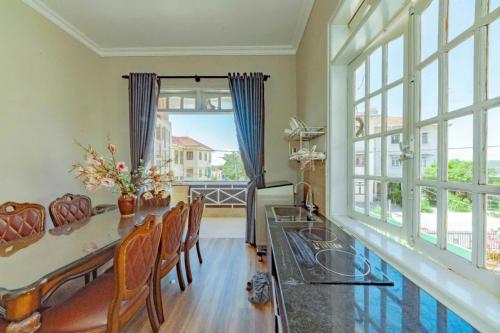 Mộc Thiện Tâm Homestay في دالات: غرفة طعام مع طاولة وكراسي ونافذة كبيرة