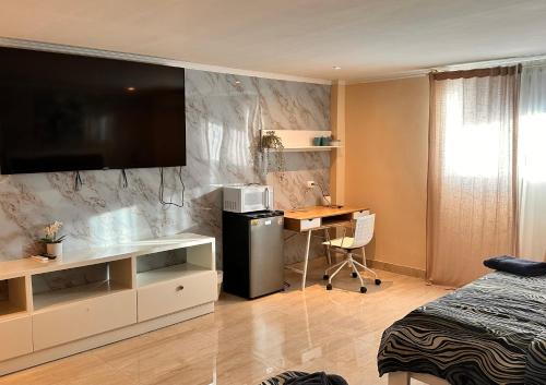 a bedroom with a bed and a desk with a computer at Noe hotel in Punta Cana