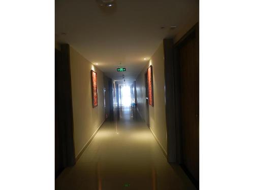 a long hallway with a light at the end of it at Wing Hotel Kualanamu Airport in Medan