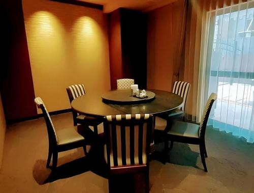 a dining room with a table and chairs and a window at Diamond Hotel Tokyo in Tokyo