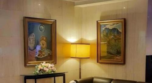 a living room with a couch and two pictures on the wall at Diamond Hotel Tokyo in Tokyo