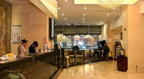 a group of people sitting at a counter in a restaurant at Fuzhou Xin Zi Yang Hotel in Fuzhou