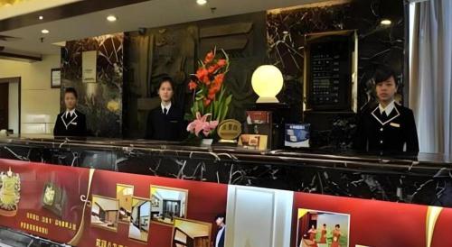three people standing behind a counter in a restaurant at Fuzhou Xin Zi Yang Hotel in Fuzhou