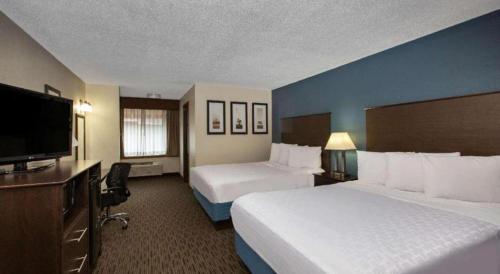 a hotel room with two beds and a flat screen tv at AmericInn by Wyndham La Crosse Riverfront-Conference Center in La Crosse