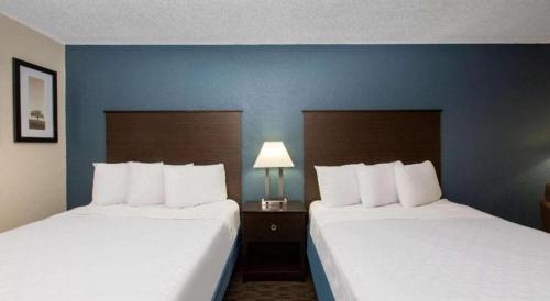 two beds in a hotel room with blue walls at AmericInn by Wyndham La Crosse Riverfront-Conference Center in La Crosse