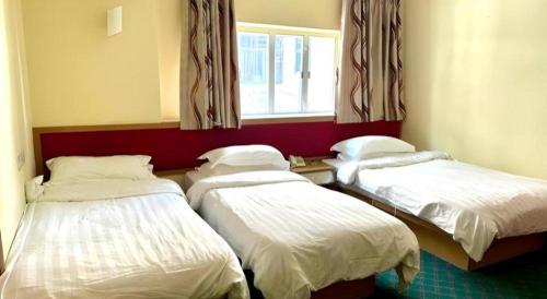 a room with two beds and a window at Man Va Hotel in Macau