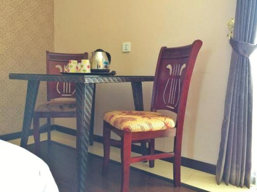 a table with two chairs and a tea kettle on it at Grand Hoyah Hotel in Olongapo