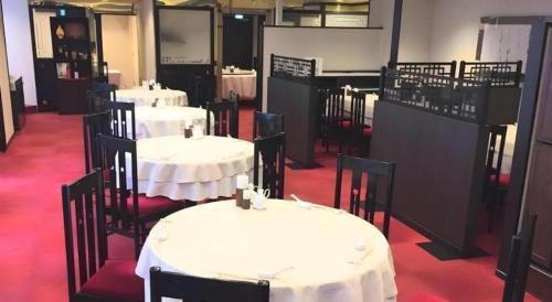 a group of tables and chairs with white table cloths at Oita Century Hotel in Oita