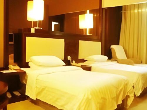 a hotel room with two beds and two chairs at Lijiang Waika Hotel in Lijiang