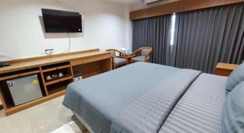 a bedroom with a bed and a flat screen tv at New Siya in Maha Sarakham