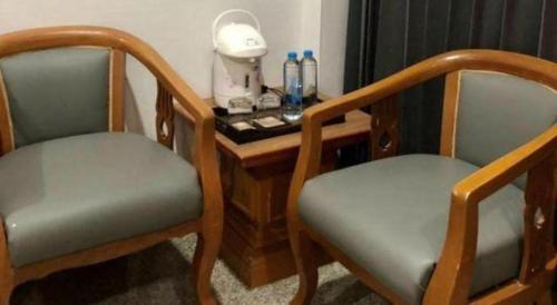 two chairs sitting next to a wooden desk with a telephone at New Siya in Maha Sarakham