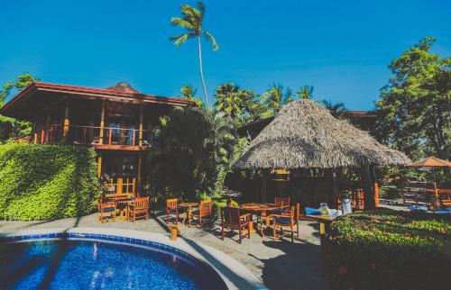 坦博爾的住宿－Tambor Tropical Beach Resort- Adults Only，一个带游泳池和椅子的度假胜地和一座建筑