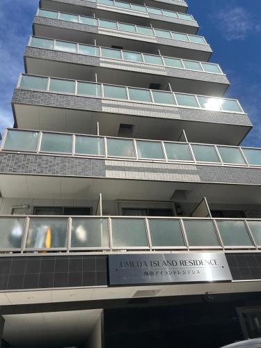 a tall building with a sign in front of it at Lucky House 喜屋 in Osaka