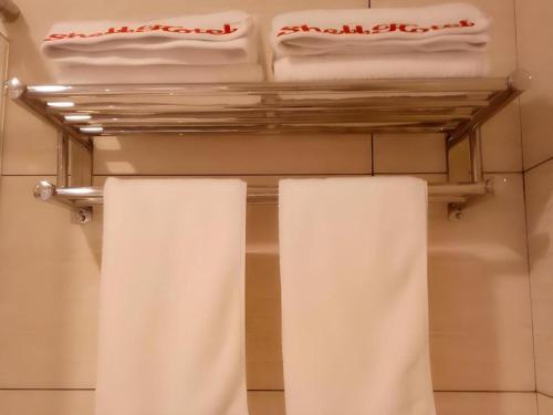 two white towels on a rack in a bathroom at GreenTree Inn Shangrao Qianshan hekou old town Xinjiang longting shell hotel in Shangrao