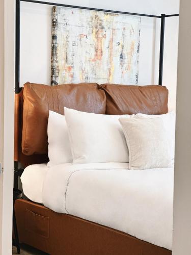 a bed with white pillows and a brown headboard at Downtown 5B2B Apt, Sleeps 10, Near PPAC & Events in Providence