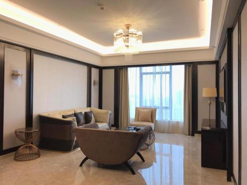a living room with a couch and a chair at Enping Yucca Hotel in Enping