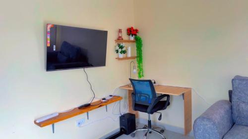 une pièce avec un bureau, une chaise et une télévision dans l'établissement The Haven Grove Naivasha, à Naivasha