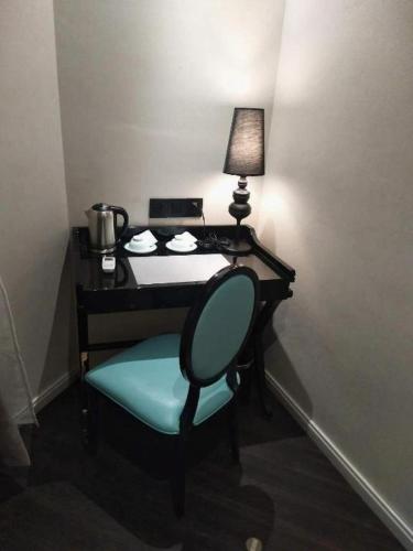a desk with a chair and a lamp in a room at Xana Lite Shenyang Beiling Park Liaoning Building Branch in Shenyang