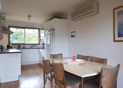 a kitchen and dining room with a table and chairs at Sandpiper at Jervis Bay - Rustic Retreat in Callala Beach