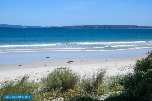 a sandy beach with the ocean in the background at Sandpiper at Jervis Bay - Rustic Retreat in Callala Beach