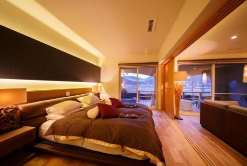 a bedroom with a large bed and a couch at Yufuin Luxury Villa -zakuro- in Yufuin