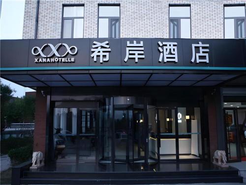 an entrance to a building with a sign with writing on it at Xana Hotelle·Ji'nan Hi-tech Zone Century Avenue Tangye in Jinan