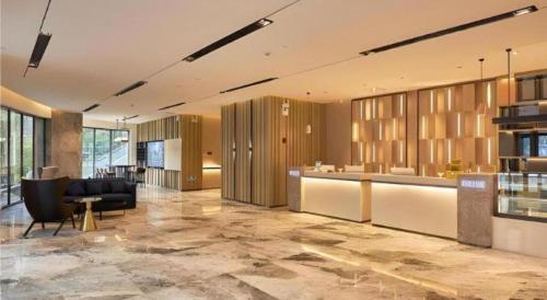an office with a lobby with a desk and chairs at Echarm Hotel Liuzhou High-speed Railway Station in Liuzhou