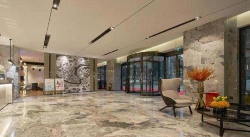 a large lobby with a chair and a table at Echarm Hotel Liuzhou High-speed Railway Station in Liuzhou