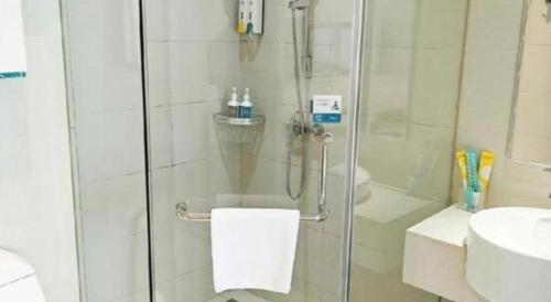 a shower with a glass door next to a sink at City Comfort Inn Wuhan Guanggu Textile University in Wuhan