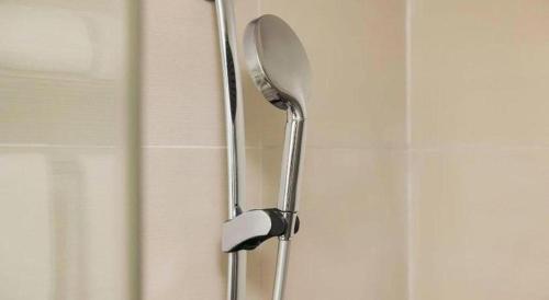 a shower door with a shower head in a bathroom at City Comfort Inn Wuhan Guanggu Textile University in Wuhan