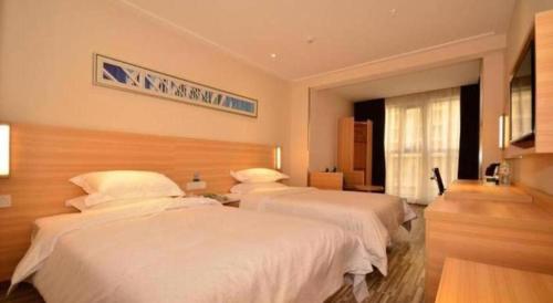 a bedroom with two beds and a sign on the wall at City Comfort Inn Wuhan Guanggu Textile University in Wuhan